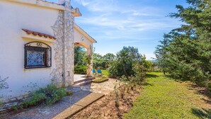 A stone building with a tiled roof, a window with decorative ironwork, and a pathway leading to a seating area. - House Ondina (16469-K1) - Medulin (Medulin)