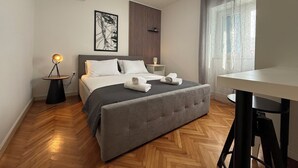 A modern bedroom with a bed, bedside table, and a desk. - Apartments Hodak (16589-A1) - Pula (Pula)