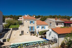 A residential area with stone buildings, a swimming pool, and a clear blue sky. - Apartments Hodak (16589-A1) - Pula (Pula)