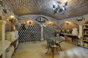 A wine cellar with brick arches, wine racks, and a table with chairs. - Villa Sunny Flowers (16659-K1) - Medulin (Medulin)