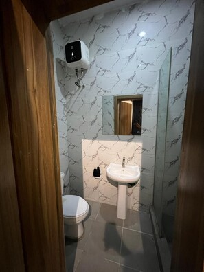 Une petite salle de bain avec des toilettes, un lavabo et un miroir.