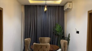 A dining area with a round wooden table and six upholstered chairs. - 3 Bedroom En-Suite, Wi-Fi, Secured, 24/7 Power (Lekki)
