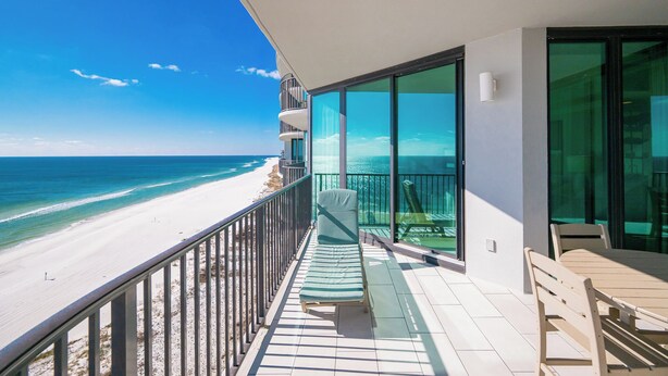 En balkon med udsigt over strand og hav.