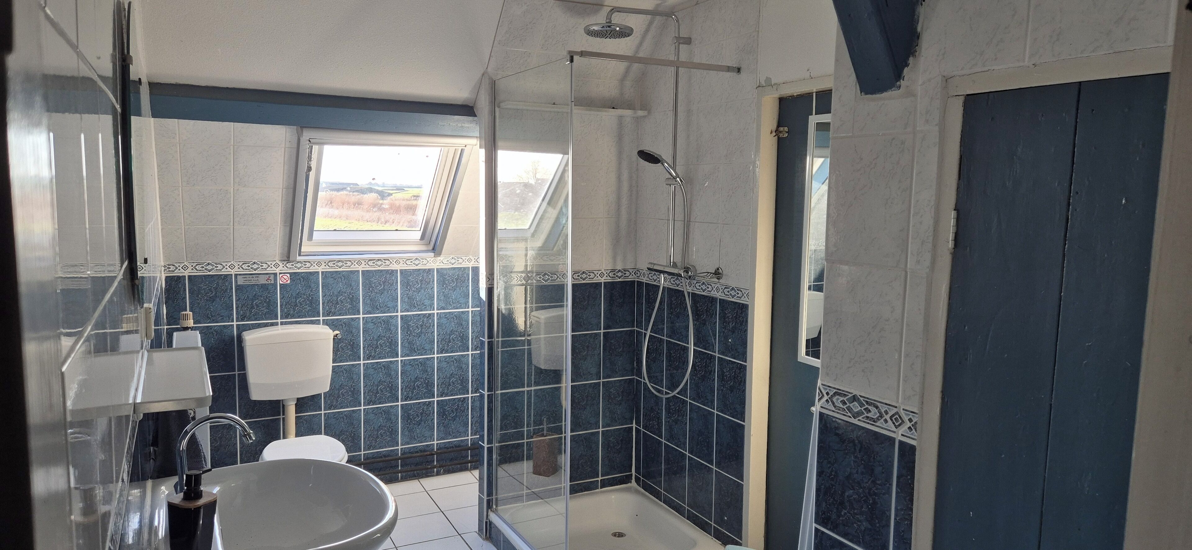 A bathroom with a shower, toilet, and sink.