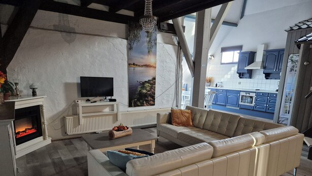 Ein modernes Wohnzimmer mit Kamin, Sofa und Fernseher.