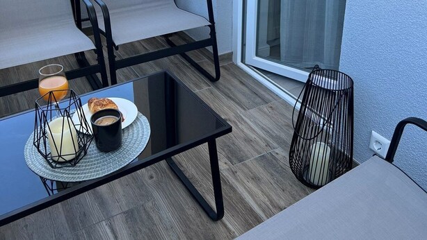 A balcony with a table, two chairs, a glass of orange juice, a plate with food, and a candle. - Apartments Vuletic (73661-A3) - Medulin (Medulin)