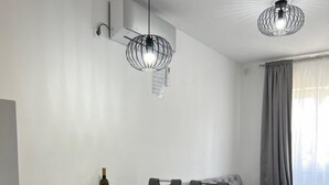 A modern dining area with a glass table, black chairs, and a sofa. There are two pendant lights and a window with curtains. - Apartments Vuletic (73661-A3) - Medulin (Medulin)