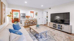 A modern living room with a sofa, coffee table, and TV. - Porter Condos (Ocean Springs)