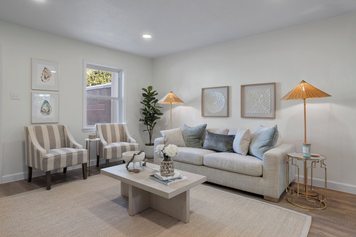 A living room with a sofa, two armchairs, a coffee table, and two floor lamps.