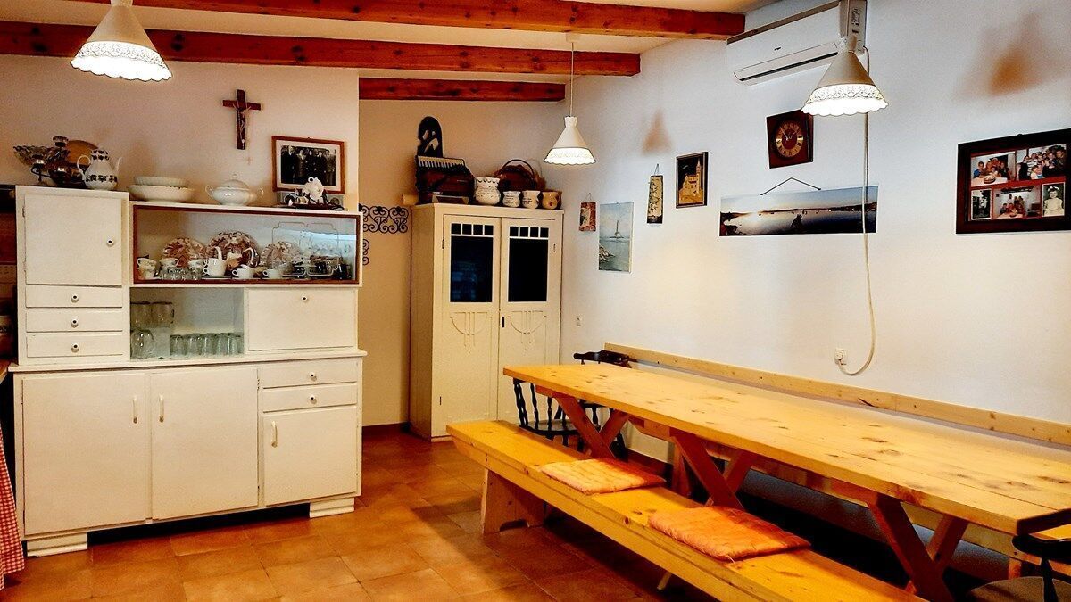 Una cocina acogedora con vigas de madera, un banco rústico y una mesa de comedor.