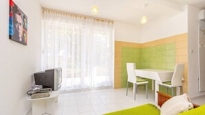 Une chambre moderne équipée d’un coin repas, d’une télévision et d’un lit.