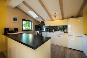 A modern kitchen with a central island, white cabinetry, and a black countertop. - House Fasana (73836-K1) - Fazana (Fazana)