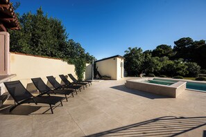 Ein Poolbereich mit Liegestühlen und einem kleinen Pool.