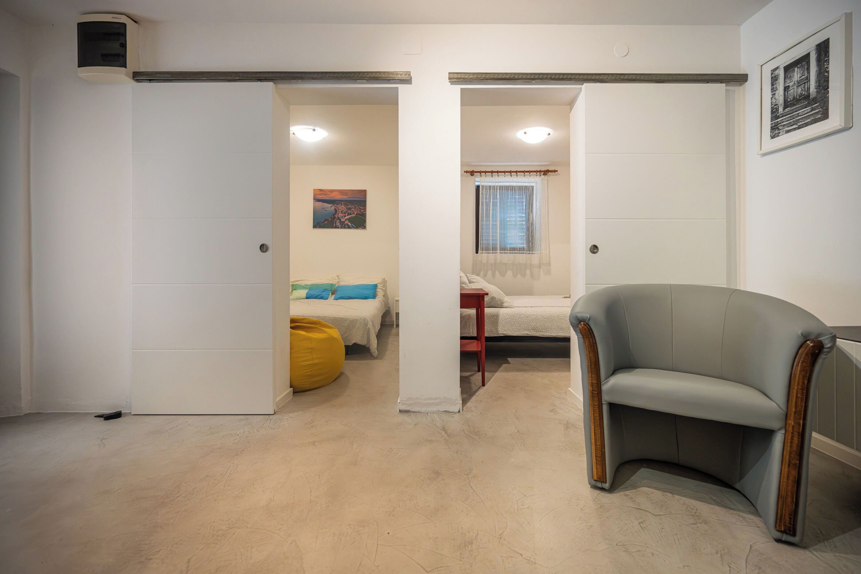 A room with a bed, a chair, and a window with curtains.