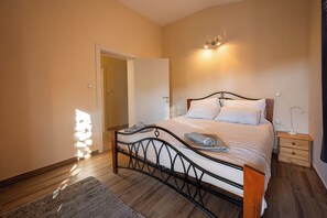A bedroom with a bed, bedside tables, a nightstand, a door, and a wall-mounted light fixture. - House Fasana (73836-K1) - Fazana (Fazana)