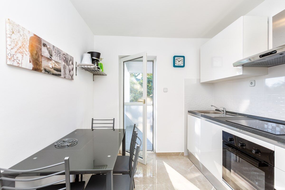 Une cuisine moderne avec un coin repas, une cuisinière, un four et une fenêtre donnant sur un beau paysage.