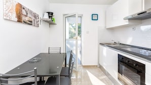 Una cocina moderna con comedor, estufa, horno y ventana con vistas.