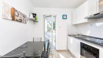 Une cuisine moderne avec un coin repas, une cuisinière, un four et une fenêtre donnant sur un beau paysage.