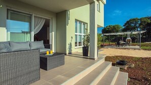 A modern outdoor living area with a sofa, a coffee table, and a dining set.