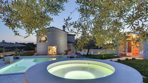 Una casa moderna con piscina e vasca idromassaggio.