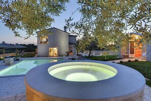 Une maison moderne avec une piscine et un jacuzzi.