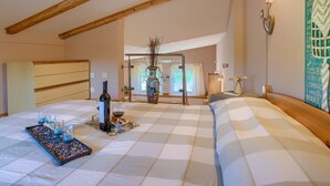Une chambre à coucher avec une couvre-lit à carreaux, une table de chevet ornée d’un vase et d’une bouteille, et une fenêtre avec des rideaux.