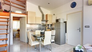 Une cuisine compacte comprenant un coin repas, une cuisinière encastrée et un four à micro-ondes.