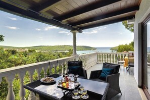 A balcony with a table set for dining, overlooking a scenic landscape with hills and a body of water. - Villa Mima (73973-K1) - Banjole (Banjole)