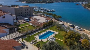 Una proprietà costiera con piscina, parcheggio e vista sul mare.