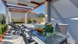 An outdoor dining area with a glass table, chairs, and a pergola overhead. - Villa Sunny Home (74045-K1) - Vodnjan (Vodnjan)