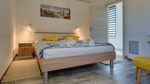 A bedroom with a bed, bedside tables, a painting, and a door with blinds. - Villa Sunny Home (74045-K1) - Vodnjan (Vodnjan)