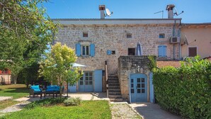 A stone building with a garden area, outdoor seating, and a staircase leading to a door. - Villa Sherpa (74136-K1) - Porec (Porec)
