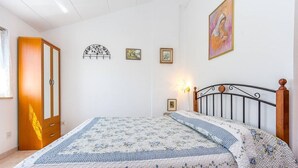 Ein Schlafzimmer mit einem Bett, einem Kleiderschrank und Wanddekorationen.