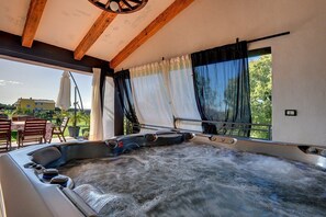 Un jacuzzi con techo de madera y amplias ventanas.
