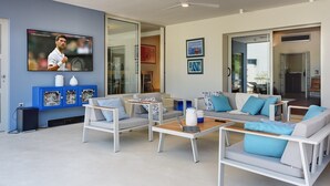 A modern living room with a flat-screen TV, a ceiling fan, and a blue cabinet with decorative items. - Villa Balizerka (74154-K1) - Pula (Pula)