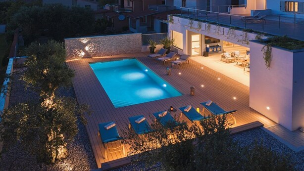 A modern outdoor pool area with lounge chairs and a bar, surrounded by a landscaped garden and a view of the neighborhood. - Villa Balizerka (74154-K1) - Pula (Pula)