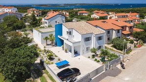 A coastal residential area with modern houses, a clear blue sky, and a view of the sea. - Villa Balizerka (74154-K1) - Pula (Pula)