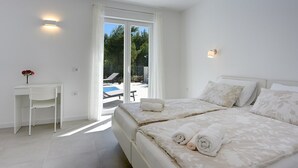 Ein Schlafzimmer mit zwei Betten, einem Schreibtisch und einem Stuhl.