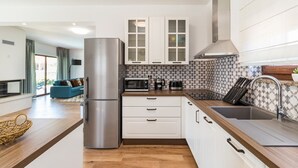 A compact kitchen with white cabinets, a stainless steel refrigerator, a microwave, and a coffee maker. - Villa Roma (74193-K1) - Pula (Pula)