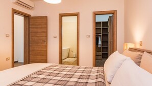 A bedroom with a bed, a wardrobe, and a bathroom visible through an open door. - Villa Roma (74193-K1) - Pula (Pula)
