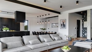 A modern living room with a grey sofa, a black coffee table, and a dining area with a black table and chairs. - Villa Aquarius (74198-K1) - Pula (Pula)