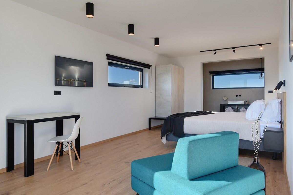 Une chambre d’hôtel moderne équipée d’un lit, d’un bureau, d’une chaise et d’un canapé.
