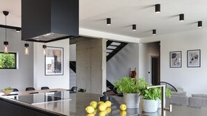 A modern kitchen with a central island, a dining area with a long table, and a staircase leading to another level. - Villa Aquarius (74198-K1) - Pula (Pula)