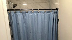 A bathroom with a shower curtain, toilet, and sink.