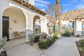 A courtyard with a patio, a door, and a chair. - Family Friendly Legacy Villas Retreat- Mountain Views (La Quinta)