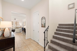 A staircase with a handrail, a door, and a wall-mounted mirror. - Family Friendly Legacy Villas Retreat- Mountain Views (La Quinta)