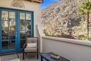 A balcony with a chair, a table, and a potted plant. - Family Friendly Legacy Villas Retreat- Mountain Views (La Quinta)