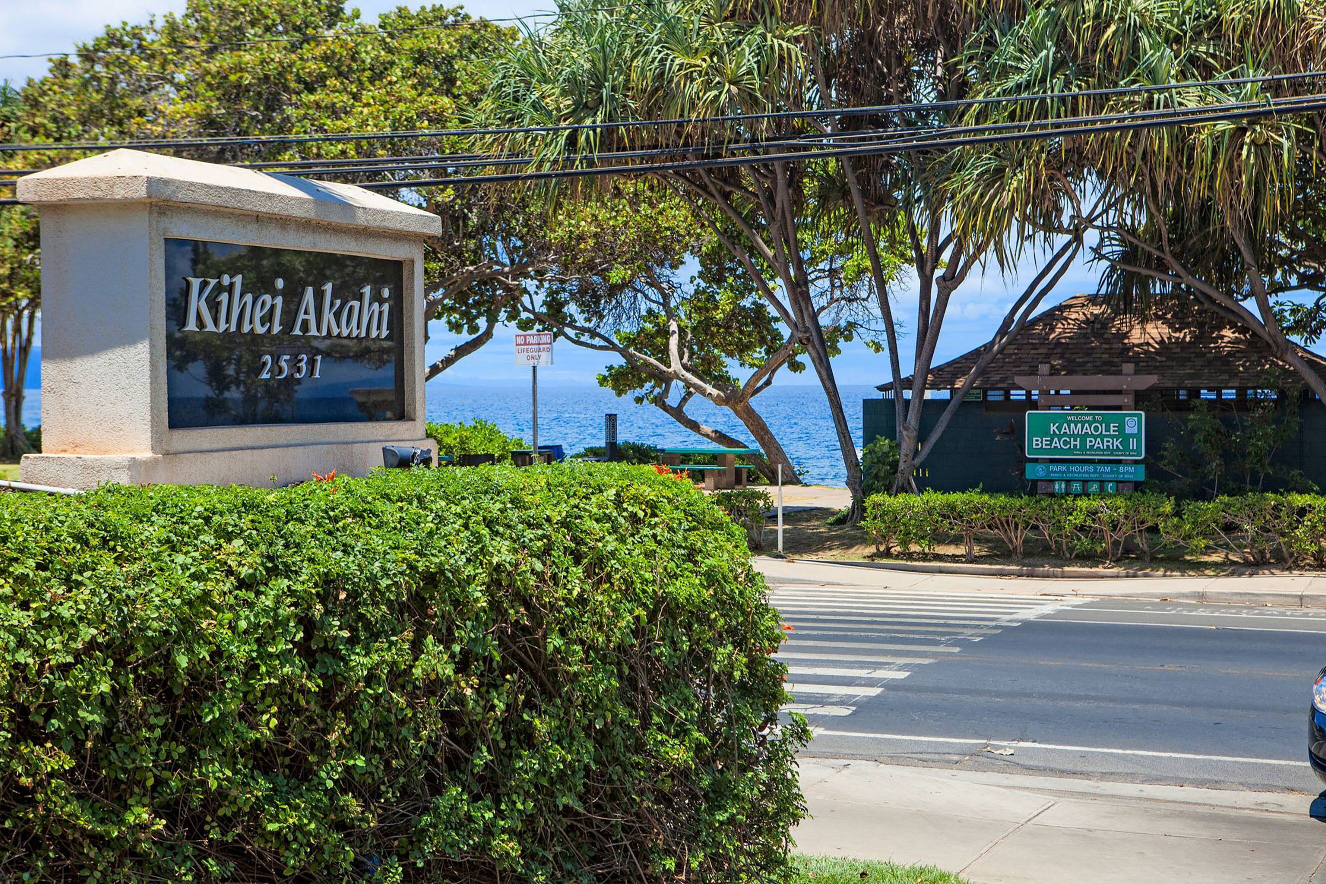 A street sign with "Kihei Akahi 2531" and a welcome sign for "Kamaole Beach Park II".