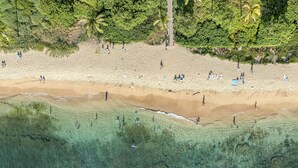 A beach with clear water, sandy shore, and trees. - Honua Kai Resort Konea 505 Ocean & Sunset View 2BR at Kaanapali (Lahaina)
