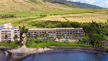 Un resort con varias construcciones, piscina y playa.
